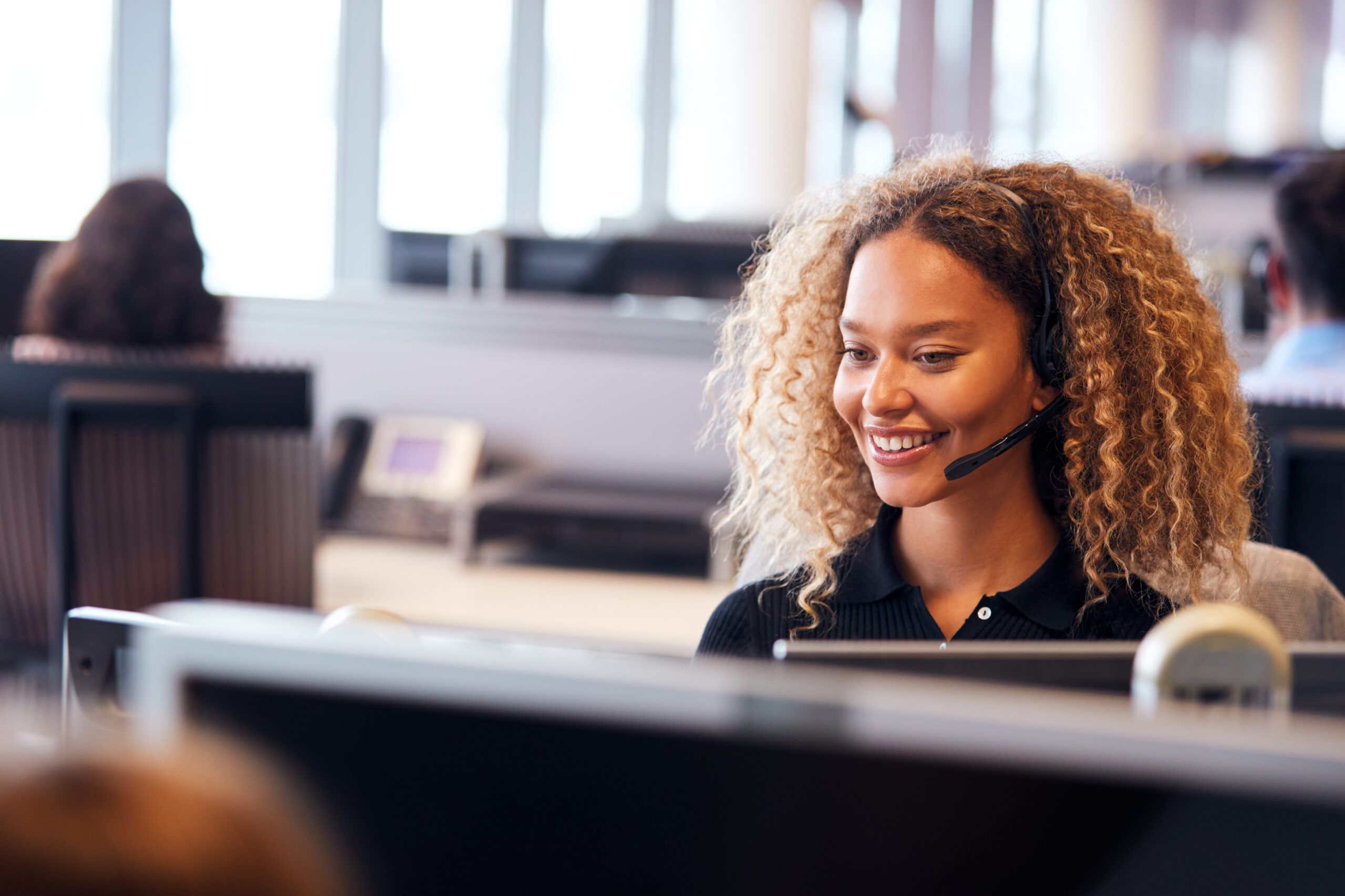Customer service representative wearing a headset while handling customer conversations in a contact center